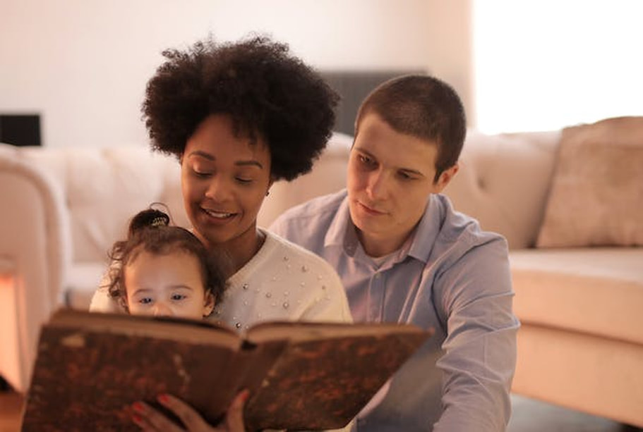 A young couple reads their child a bedtime story