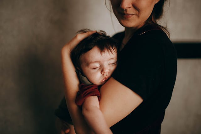 A mom holding her sleeping child