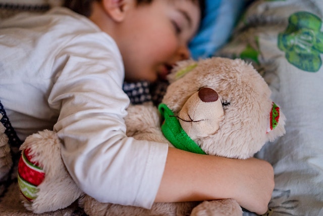 A boy sleeping with his Teddy Bear